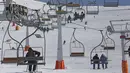 Pemain ski menggunakan kursi gantung di resor ski Tochal di luar ibu kota Teheran, Iran (1/1/2022). Di tengah polusi udara dan kesengsaraan ekonomi, penduduk Teheran menemukan kenyamanan di resor ski di utara Teheran di pegunungan Alborz. (AP Photo/Vahid Salemi)