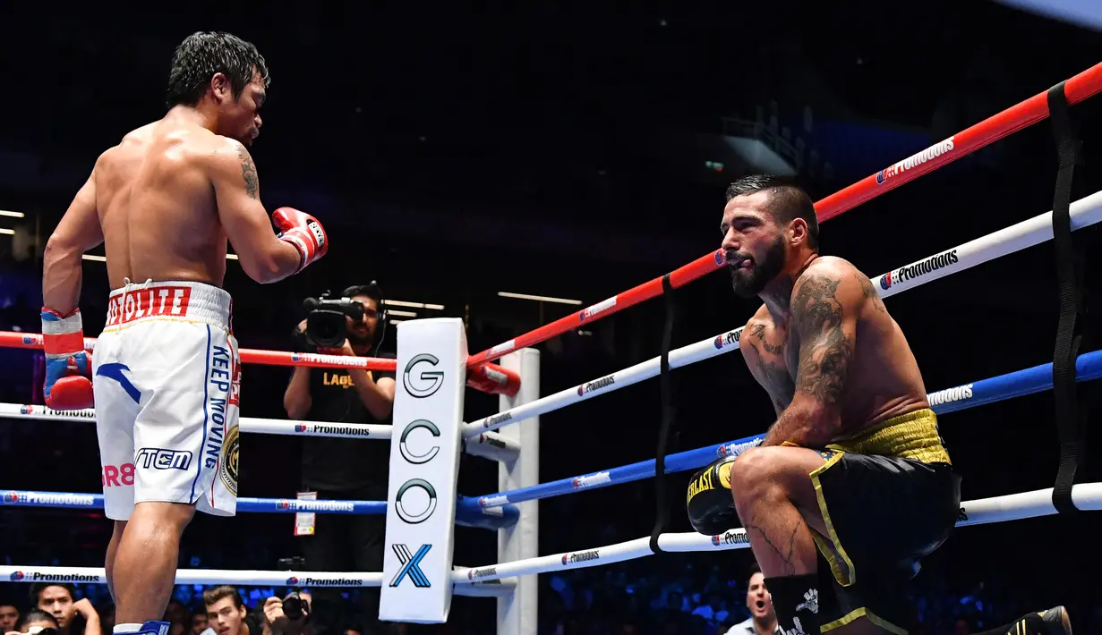 Petinju Argentina, Lucas Matthysse terjatuh saat melawan petinju Filipina Manny Pacquiao saat bertanding pada kelas welter versi WBA di Axiata Arena di Kuala Lumpur, Malaysia (15/7). Pacquiao menang KO atas Matthysse di Ronde ke 7. (AFP Photo/Mohd Rasfan)