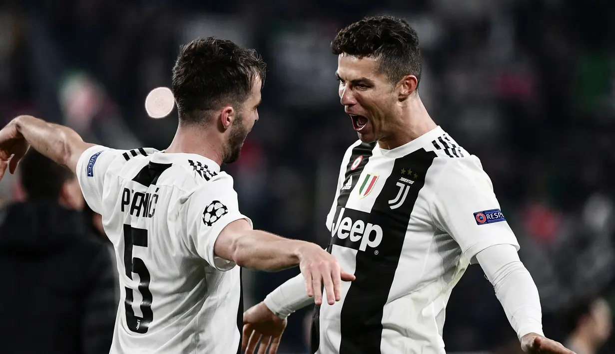 Pemain Juventus Miralem Pjanic (kiri) merangkul Cristiano Ronaldo usai mereka mengalahkan Atletico Madrid pada leg kedua babak 16 besar Liga Champions di Allianz Stadium, Turin, Selasa (12/3). Atletico tersingkir dari Liga Champions.(Marco BERTORELLO/AFP)