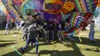 Warga membantu mengangkat layang-layang raksasa untuk ditampilkan pada Hari Semua Orang Kudus sebagai bagian dari perayaan Hari Kematian di Santiago Sacatepequez, Guatemala, 1 November 2021. Perayaan digelar dengan sejumlah pembatasan untuk mengekang penyebaran COVID-19. (AP Photo/Moises Castillo)