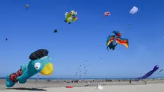 Orang-orang menerbangkan layang-layang berbagai bentuk dan warna dalam Festival Layang-Layang Internasional ke-32 di pantai Berck-sur-Mer, Prancis utara, 18 April 2018. Kegiatan internasional ini berlangsung hingga 22 April 2018. (Denis Charlet/AFP)