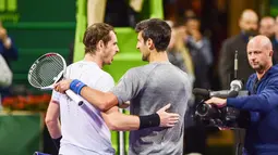 Petenis Serbia, Novak Djokovic dan petenis Skotlandia, Andy Murray saling berangkulan usai final turnamen Qatar Terbuka di Doha, Sabtu (7/1). Djokovic berhasil meraih gelar Qatar Open 2017 dengan skor 6-3, 5-7, 6-4. (AP Photo/Alexandra Panagiotidou)