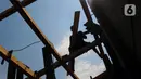 Tukang kayu memperbaiki kapal motor di Pelabuhan Kalibaru, Jakarta, Rabu (8/3/2023). Tukang kayu mengalami kesulitan bahan baku yang mulai jarang. (merdeka.com/Imam Buhori)