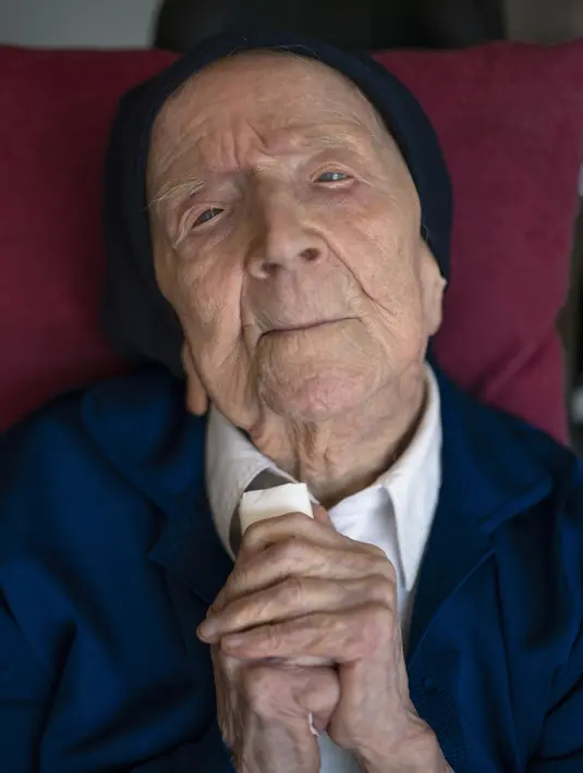 <p>Suster Andre berpose untuk dipotret di panti jompo Sainte Catherine Laboure tempatnya tinggal, di Toulon, Prancis selatan, Rabu (27/4/2022). Dengan kematian Kane Tanaka asal Jepang pada usia 119 tahun, manusia tertua di dunia sekarang adalah Lucile Randon yang merupakan seorang biarawati Prancis yang dikenal sebagai Suster Andre, berusia 118, menurut The Gerontology Research Group. (AP Photo/Daniel Cole)</p>