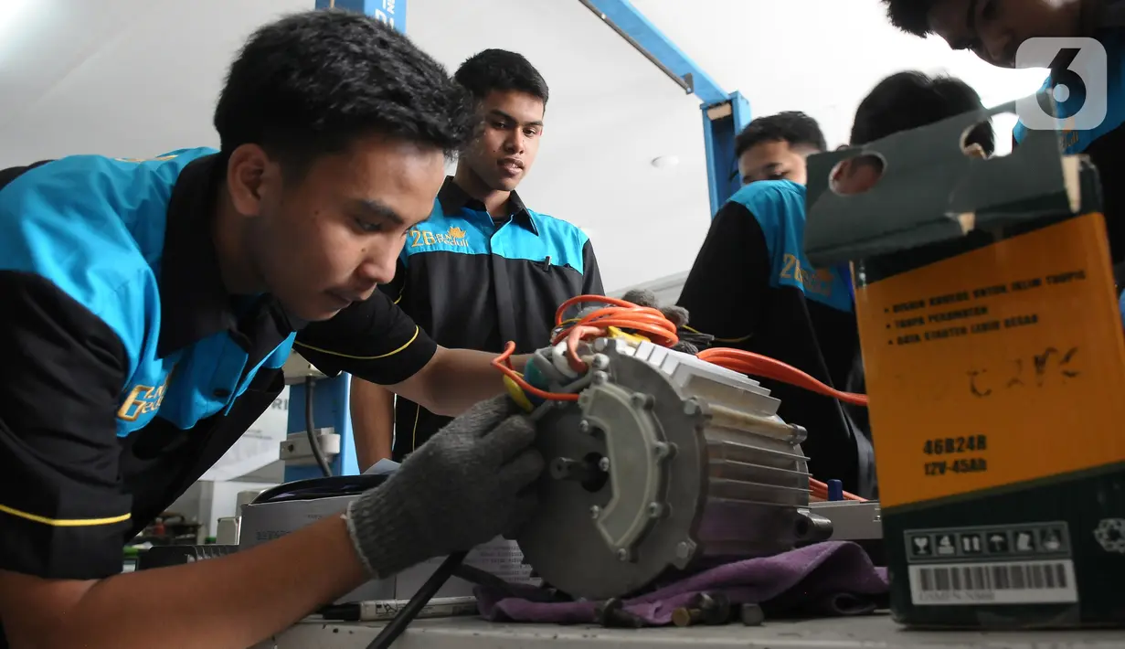 Pelajar SMK Negeri 26 Jakarta melakukan pengecekan instalasi part konversi mobil listrik di Bengkel Otomotif SMKN 26, Jakarta, Rabu (13/5/2023). (merdeka.com/Imam Buhori)