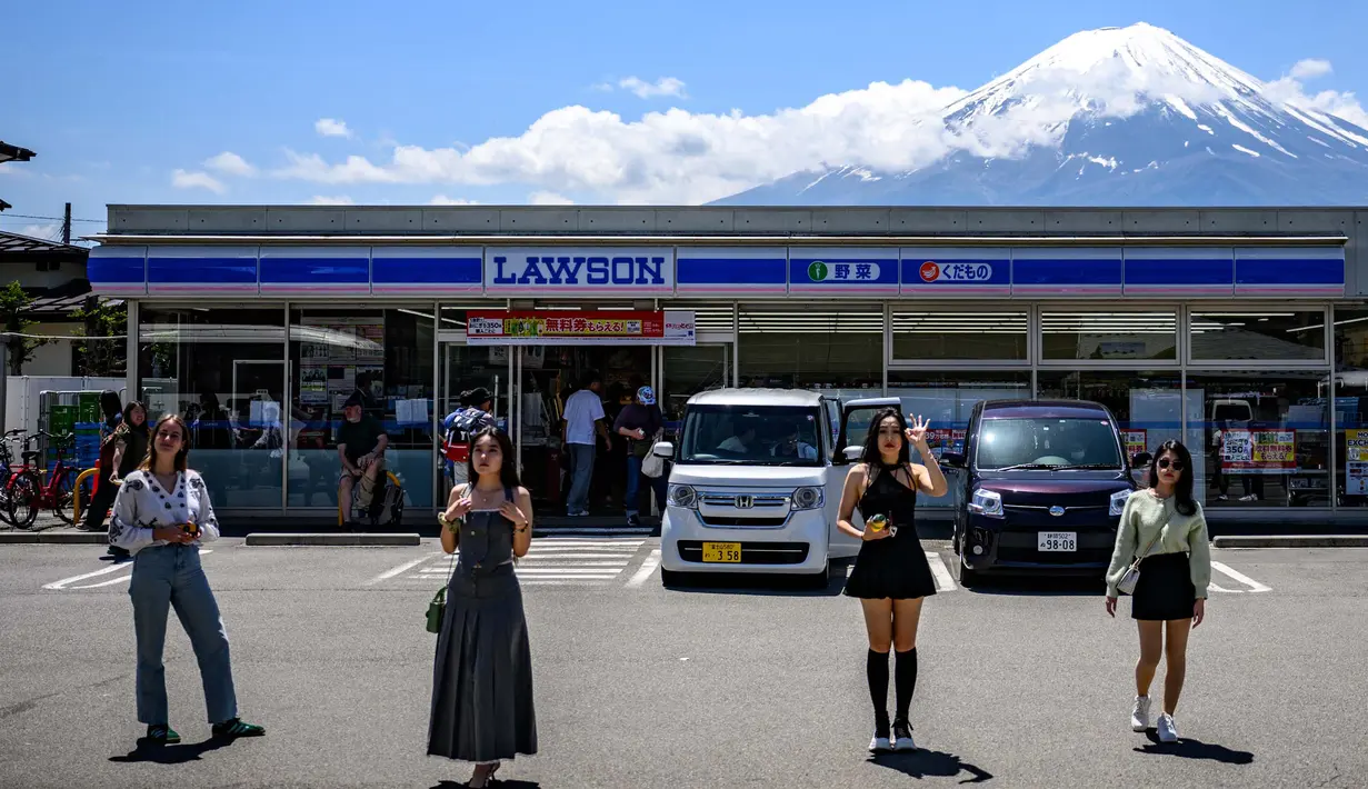 Lokasi ini menjadi salah satu sudut pandang yang sangat populer, karena Gunung Fuji yang megah muncul tepat di belakang salah satu toko serba ada. (Philip FONG/AFP)