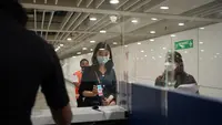 Salah seorang penumpang pesawat menunjukkan QR-Code kepada petugas Bea Cukai saat di area kedatangan bandara. (Istimewa)