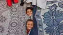 Anak-anak bermain di sebuah tenda darurat untuk warga Palestina yang mengungsi dari Gaza utara, di stadion Yarmouk yang rusak di Kota Gaza pada 14 Oktober 2024. (Omar AL-QATTAA/AFP)