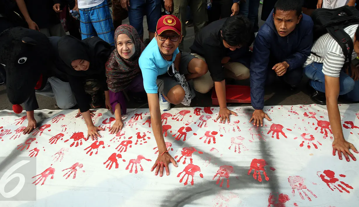 Pengunjung CFD membubuhkan cat telapak tangan saat gerakan Deklarasi Anti Korupsi di Bundaran HI, Jakarta, Minggu (27/11). Aksi ini dilakukan jelang diperinngatinya Hari Anti Korupsi Sedunia  9 Desember. (Liputan6.com/Johan Tallo) 
