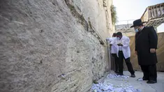 Petugas membersihkan catatan doa yang ditempatkan jemaah di celah-celah Tembok Barat, tempat doa paling suci Yudaisme, di Kota Tua Yerusalem, Rabu (25/8/2021). Menjelang tahun baru Yahudi, Tembok Barat mulai dibersihkan untuk memberi ruang bagi catatan baru jemaah berdoa. (AP Photo/Ariel Schalit)