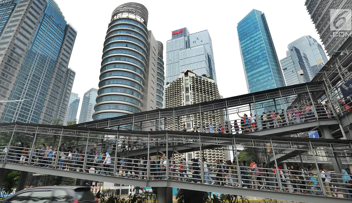 Calon penonton rela antre hingga Halte Bus Transjakarta Senayan untuk mengikuti Closing Ceremony Asian Games 2018 di Stadion GBK, Jakarta, Minggu (2/9). Mereka rela antre sejak pukul 08.00 pagi. (merdeka.com/Arie Basuki)