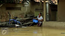 Warga keluar dari dalam salah satu gang yang ada di kawasan Rawajati, Jakarta, Selasa (8/3/2016). Akibat banjir kiriman dari Bogor, ratusan rumah di kawasan Rawajati Kalibata terendam hingga kedalaman 120cm. (Liputan6.com/Helmi Fithriansyah)
