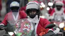 Seorang pengendara yang mengenakan kostum Sinterklas mengendarai motor selama parade Sinterklas di Beograd, Serbia, Minggu (26/12/2021). Mereka melakukan konvoi menuju rumah sakit anak-anak untuk membagikan mainan hadiah Natal kepada pasien di sana. (AP Photo/Darko Vojinovic)