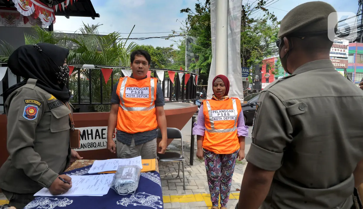 Warga pelanggar PSBB dihukum menyanyikan lagu Indonesia Raya saat razia di Jalan Raya Cinere, Depok, Jawa Barat, Senin (24/8/2020). Razia ditujukan bagi warga yang tidak mengenakan masker untuk menekan penyebaran COVID-19. (merdeka.com/Arie Basuki)