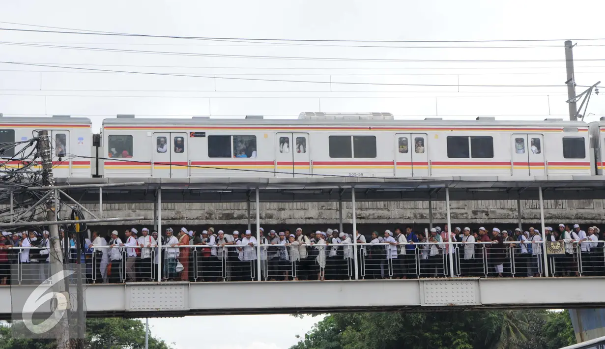 Peserta aksi 2 Desember memadati jembatan penyeberangan orang (JPO) di kawasan Pasar Baru, Jakarta, Jumat (2/12). Aksi berjalan lancar dan damai. (Liputan6.com/Helmi Afandi)