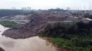 Foto udara memperlihatkan alat berat memindahkan tumpukan sampah dari Tempat Pembuangan Akhir (TPA) Cipeucang yang masuk ke area Sungai Cisadane, Serpong, Tangerang Selatan, Rabu (3/6/2020). Sebelumnya, pada Jumat (22/5/) lalu turap yang menopang TPA tersebut jebol. (Liputan6.com/Helmi Fithriansyah)