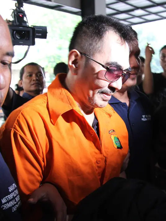 Tiba di Polda, Gatot Brajamusti mengenakan baju seragam tahanan warna oranye dan berkaca mata hitam. Tidak sepatah kata pun terucap dari mulut guru spiritual artis itu. (Nurwahyunan/Bintang.com)