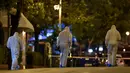 Ahli forensik mencari bukti setelah ledakan bom menghantam sebuah kantor cabang bank asal Yunani, Eurobank, di pusat Kota Athena, Rabu (19/4). Serangan ini menyebabkan kerusakan gedung bank dan sejumlah bangunan di sekitarnya. (LOUISA GOULIAMAKI/AFP)