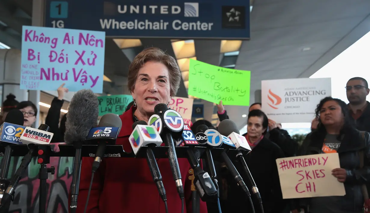 Perwakilan demonstran menyampaikan orasinya di depan terminal United Airlines terkait pengusiran penumpang di pesawat United Airlines di Bandara Internasional O'Hare, Chicago, AS, Selasa (11/4). (Scott Olson / Getty Images / AFP)