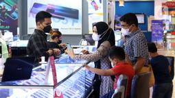 Pedagang melayani pembeli di toko ponsel pusat perbelanjan Kota Tangerang, Banten, Rabu (10/11/2021). Sejak operator seluler mengadopsi teknologi 5G yang menawarkan akses data super cepat, produsen ponsel menikmati lonjakan permintaan smartphone 5G. (Liputan6.com/Angga Yuniar)