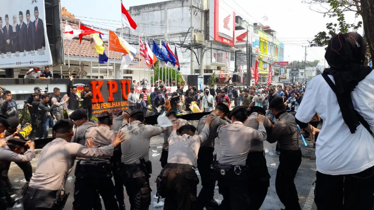 Personil Kepolisian saat menahan massa aksi
