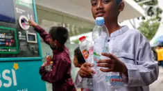 Seorang anak membawa botol plastik bekas untuk dimasukkan ke Reverse Vending Machine (RVM) di halaman Masjid Istiqlal, Jakarta, Senin (5/6/2023). (Liputan6.com/Angga Yuniar)