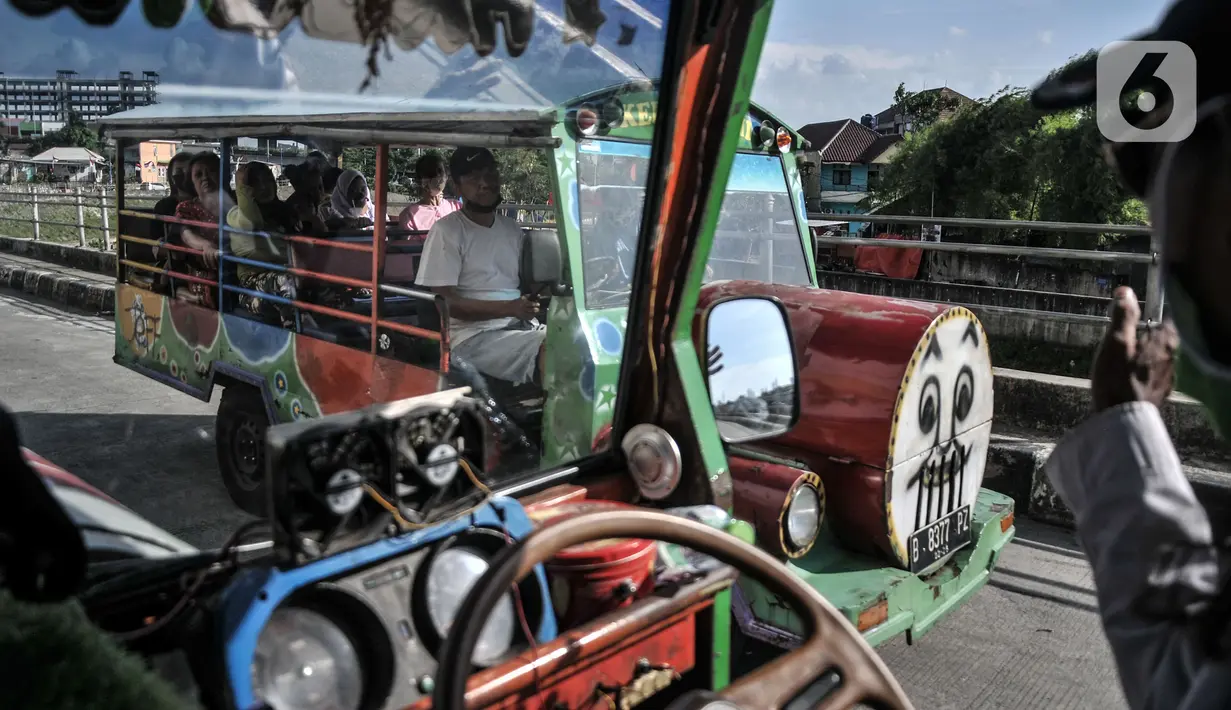 Gondrong (47) saat menyapa sopir odong-odong yang berpapasan di Jalan Inspeksi Ciliwung, Jatinegara, Jakarta Timur, Senin (27/9/2021). Ongkos odong-odong biasanya dikenakan Rp 2.000 - Rp 3.000 untuk sekali jalan. (merdeka.com/Iqbal S. Nugroho)
