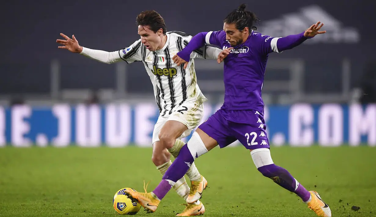 Penyerang Juventus, Federico Chiesa, berebut bola dengan pemain Fiorentina, Martín Caceres, pada laga Liga Italia di Turin, Rabu (23/12/2020). Fiorentina menang dengan skor 0-3. (Fabio Ferrari/LaPresse via AP)