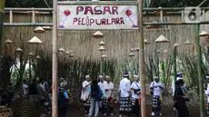 Sejumlah wisatawan menikmati suasana Pasar Pelipur Lara di kawasan hutan bambu, Desa Penglipuran di Kabupaten Bangli, Bali, Rabu (16/8/2023). (Liputan6.com/Helmi Fithriansyah)