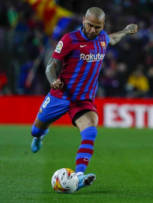 Bek Barcelona, Dani Alves berusaha mengumpan bola saat bertanding melawan Osasuna pada pertandingan lanjutan La Liga Spanyol di di stadion Camp Nou di Barcelona, Senin (14/3/2022). Barcelona menang telak atas Osasuna 4-0. (AP Photo/Joan Monfort)