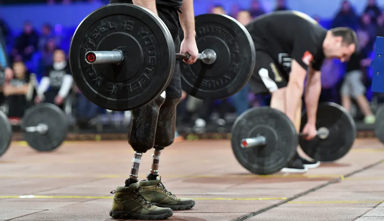Para peserta berlatih angkat beban sebelum mengikuti kompetisi final CrossFit "Game of Heroes" di Kiev, Ukraina (24/12). Kompetisi ini diikuti oleh lima belas tentara Ukraina yang cacat akibat pertempuran dengan pihak separatis. (AFP/Sergei Supinsky)