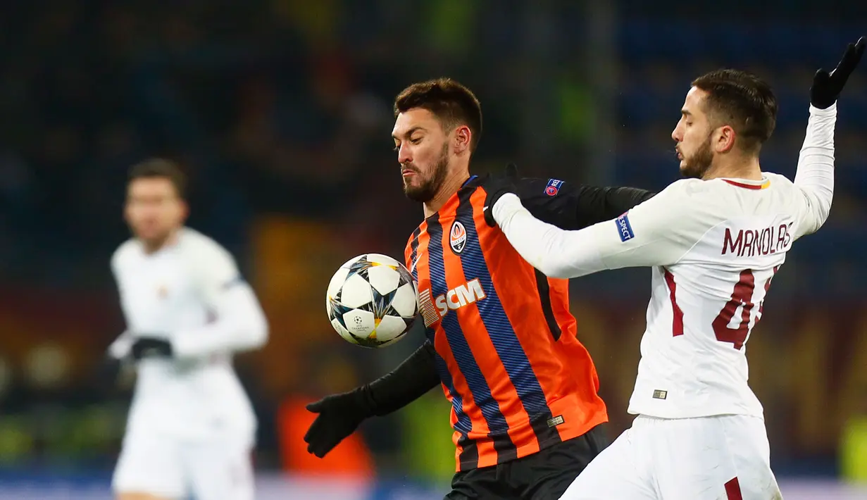 Pemain  AS Roma, Kostas Manolas dan pemain Shakhtar Donetsk, Facundo Ferreyra berebut bola pada leg pertama babak 16 besar Liga Champions di Oblasny SportKomplex Metalist, Kamis (22/2). Roma dipaksa takluk 1-2 meski lebih dahulu unggul (AP/Efrem Lukatsky)