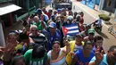Sejumlah warga yang ikut dalam rombongan pembawa abu Fidel Castro saat sampai di Cardenas, Kuba, Rabu (30/11). Abu Fidel Castro akan dimakamkan di Santiago, yang membutuhkan tiga hari perjalanan. (REUTERS)