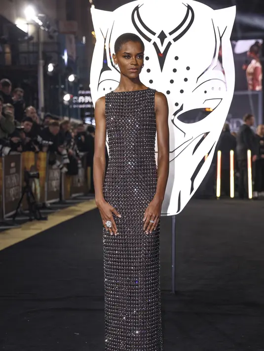 Letitia Wright berpose saat tiba menghadiri pemutaran perdana film 'Black Panther: Wakanda Forever' di London, Kamis, 3 November 2022. Riasannya lengkap dengan alas bedak yang berembun dan bibir telanjang yang mengilap. (Photo by Scott Garfitt/Invision/AP)