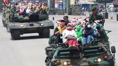 Masyarakat ikut menaiki tank saat menonton atraksi militer TNI dalam geladi resik HUT TNI ke-72 di Cilegon, Banten, Selasa (3/10). Geladi resik tersebut untuk memperingati HUT TNI ke-72 yang dilaksanakan tanggal 5 Oktober. (Liputan6.com/Angga Yuniar)