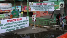 Warga melintasi palang bambu penutup pintu masuk kawasan Pasar Cileungsi, Kabupaten Bogor, Selasa (2/6/2020). Penutupan sementara kegiatan jual beli di Pasar Cileungsi terkait adanya tujuh pedagang yang positif terinfeksi virus COVID-19. (Liputan6.com/Helmi Fithriansyah)