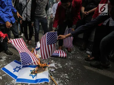 Puluhan massa membakar bendera Amerika Serikat dan Israel dalam Aksi Bela Palestina di depan Kedubes AS, Jakarta, Jumat (15/12). Mereka memprotes sikap Presiden Donald Trump yang mengakui Yerusalem sebagai Ibu Kota Israel. (Liputan6.com/Faizal Fanani)