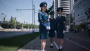 Sejumlah polisi wanita memantau jalan dikawasan sekitar di Pyongyang, Korea Utara (5/6). Menurut pihak setempat, para polisi wanita ini memiliki seragam yang berbeda untuk waktu yang berbeda dalam setahun. (AFP Photo/Ed Jones)
