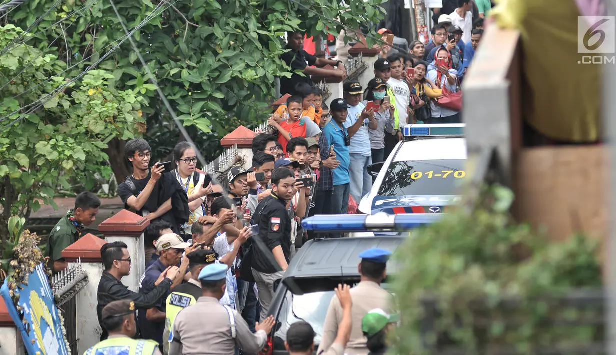 Kerumunan warga setempat menyaksikan rekonstruksi pembunuhan satu keluarga di Bojong Nangka II, Bekasi, Jawa Barat, Rabu (21/11). Rekonstruksi ini digelar oleh Tim Inafis Polda Metro Jaya dan Polres Metro Bekasi. (Merdeka.com/Iqbal S. Nugroho)