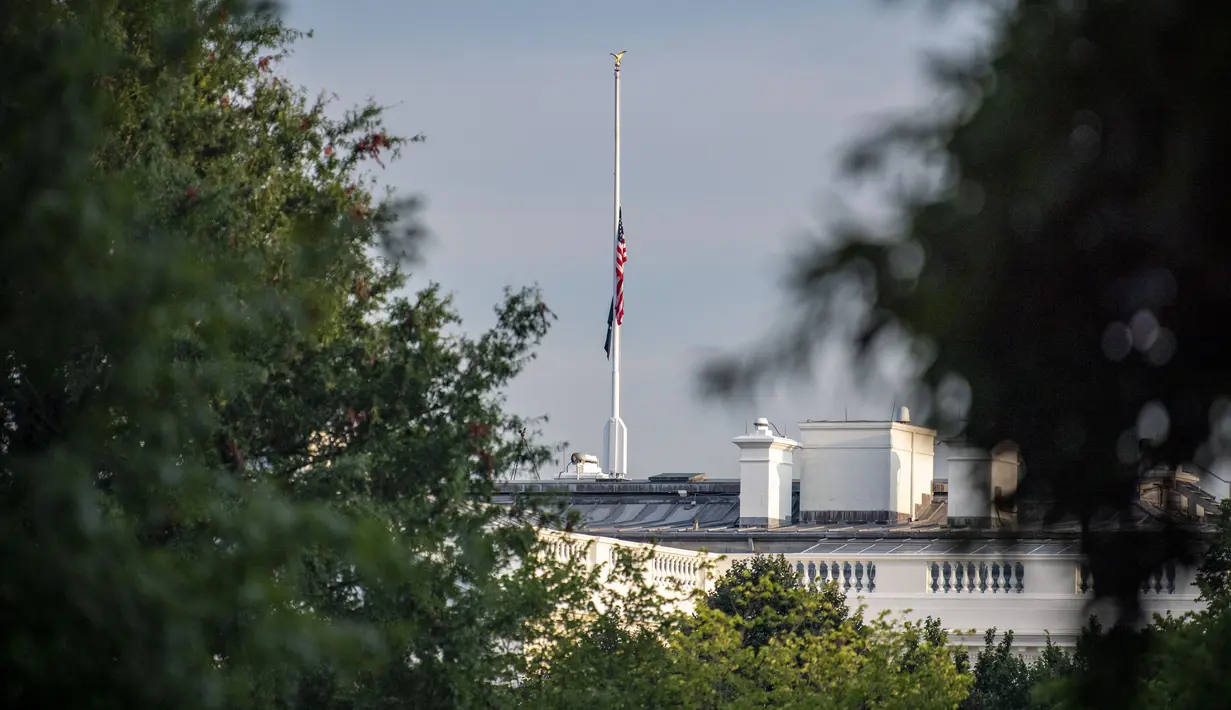 Bendera AS berkibar setengah tiang di atas Gedung Putih, pada Kamis (26/8/2021). Semua gedung federal dan fasilitas militer milik AS akan mengibarkan bendera AS setengah tiang untuk menghormati anggota marinir AS dan lainnya yang tewas dalam serangan bom di Kabul, Afghanistan. (Eric BARADAT/AFP)