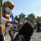 Pekerja medis memberikan imunisasi polio dari petugas medis saat berlangsung vaksinasi massal di Sigli Town Square,  Pidie, Aceh, Senin (28/11/2022).  Menyusul kejadian luar biasa (KLB) polio beberapa pekan lalu di Kabupaten Pidie, pemerintah memberikan imunisasi polio tambahan pada anak usia 0-13 tahun di seluruh wilayah Provinsi Aceh . (AP Photo/Riska Munawarah)