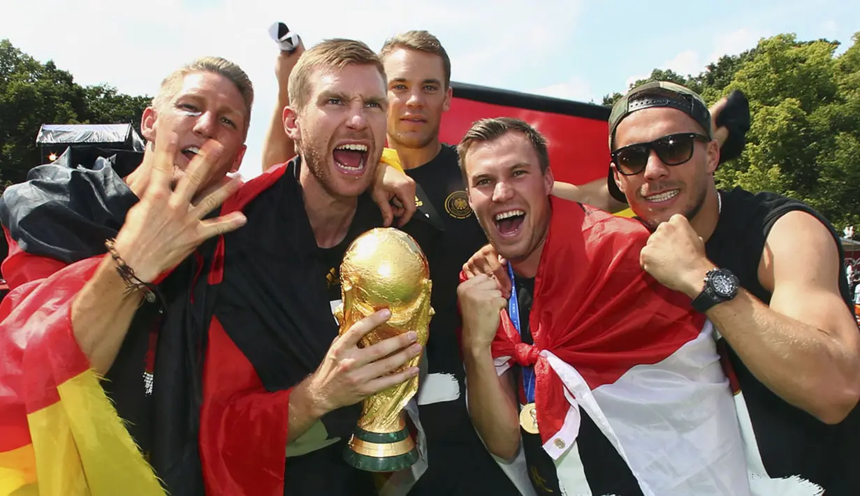 Bastian Schweinsteiger, Per Mertesacker, Manuel Neuer, Kevin Grosskreutz dan Lukas Podolski (dari kiri ke kanan) berpose sambil memegang erat trofi Piala Dunia saat perayaan kemenangan di Berlin, (15/7/2014). (REUTERS/Alex Grimm/Pool)