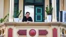 Gambar pada 3 September 2021 menunjukkan seorang perempuan melihat keluar dari balkon rumahnya di Hanoi, Vietnam, selama lockdown Covid-19. Menghadap ke jalan yang sepi, balkon kecil mereka menjadi saksi bisu terkait aktivitas yang dilakukan oleh masing-masing keluarga. (Nhac NGUYEN/AFP)