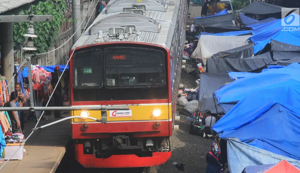 Kereta commuter line melintas di rel KRL Nambo yang dipadati aktivitas jual beli pasar dadakan, Citeureup, Bogor (20/4). Pasar dadakan ini digelar setiap hari Jumat. (Merdeka.com/Arie Basuki)