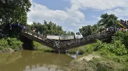 Sebuah truk berada di jembatan yang roboh di desa Phasidewa dekat perbatasan India-Bangladesh di pinggiran Siliguri di negara bagian India, Bengal Barat (7/9). Tidak ada korban dalam kejadian jembatan roboh tersebut. (AFP Photo/Diptendu Dutta)