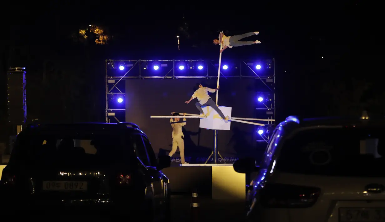 Anggota sirkus tampil secara drive-in di tempat parkir di Seoul, Korea Selatan, Jumat (25/9/2020). Acara ini digelar untuk memberikan hiburan bagi orang-orang selama wabah virus corona. (AP Photo/Ahn Young-joon)