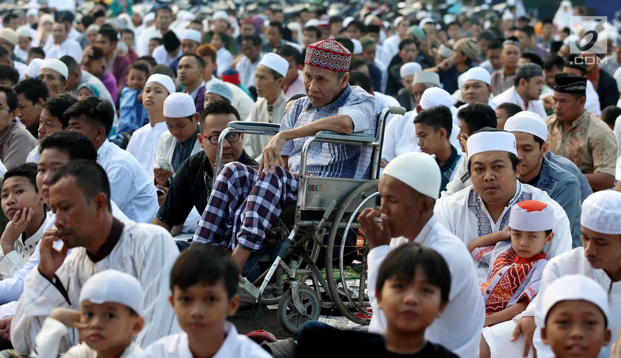 Seorang kakek duduk di kursi roda sambil mendengarkan khotbah usai Salat Idul Fitri di kawasan Senen, Minggu (25/6). Hari Raya Idul Fitri 1438 H disambut umat muslim dengan melaksanakan salat Ied di masjid dan tempat terbuka. (Liputan6.com/Johan Tallo)