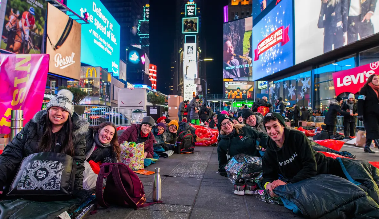 Orang-orang menghabiskan malam dengan tidur di area terbuka dalam acara World's Big Sleep Out di Times Square, New York, 7 Desember 2019. Aksi di beberapa kota besar dunia ini sebagai bagian dari upaya penggalangan dana untuk membantu para tunawisma di banyak negara. (Charles Sykes/Invision/AP)