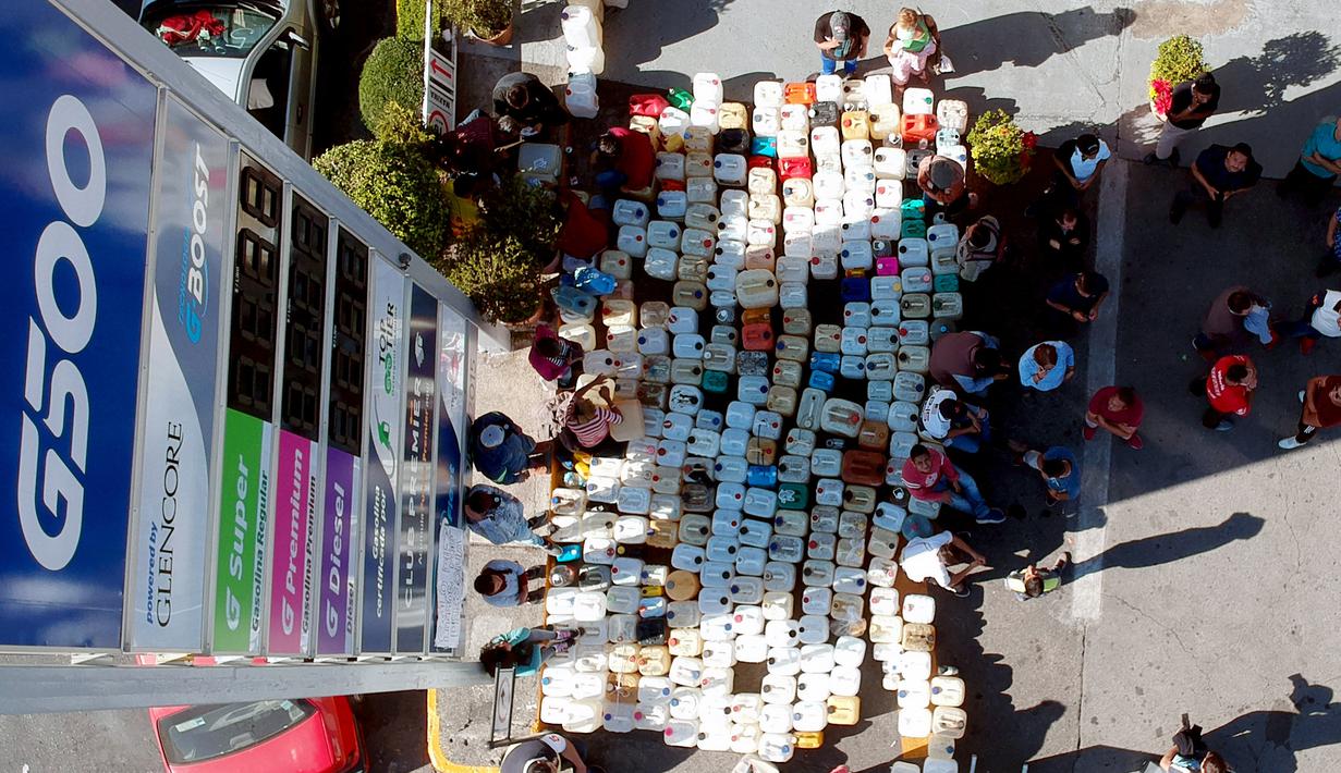 Deretan jerigen warga saat antre di tengah kelangkaan BBM di sebuah SPBU di Morelia, Meksiko, Selasa (8/1). Antrean disebabkan pasokan BBM ke beberapa negara bagian di Meksiko mengalami kekurangan akibat kasus pencurian bahan bakar. (ENRIQUE CASTRO/AFP)