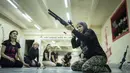 Svetlana Putilina berlatih menggunakan pistol di Kharkiv, Ukraina (30/1/2022). Putilina, yang suaminya adalah seorang Muslim di militer Ukraina. (AP Photo/Evgeniy Maloletka)
